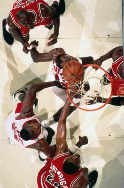 A rimbalzo in una sfida contro i Bulls di Michael Jordan, riconoscibile in alto a sinistra